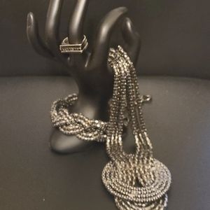 Metal sparkly necklace, bracelet and rings.